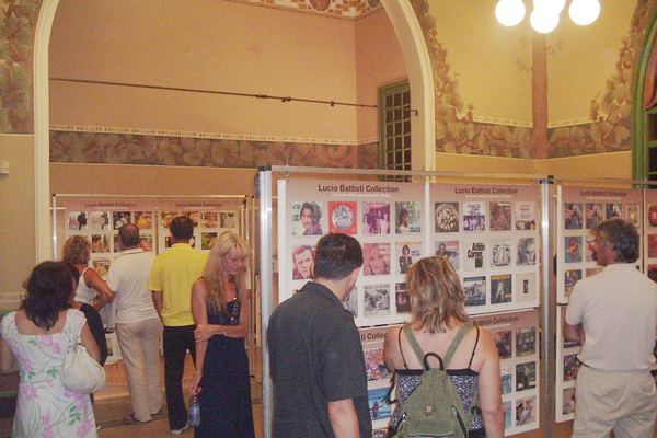 Il pubblico davanti ai pannelli della Lucio Battisti Collection in una sala affrescata